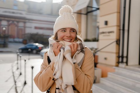 Deals des Tages: Eine junge Frau steht draußen und schmiegt ihren Schal ans Gesicht