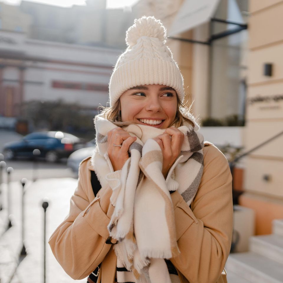 Deals des Tages: Eine junge Frau steht draußen und schmiegt ihren Schal ans Gesicht