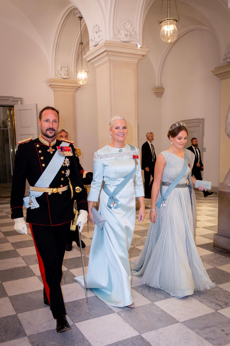 Da scheint sich aber jemand auf die große Party zu freuen. Mette-Marit von Norwegen schreitet mit Ehemann Haakon in den Festsaal auf Schloss Christiansborg und brilliert in einem Kleid von Peter Dundas und im pastellfarbenen Partnerlook mit Tochter Ingrid Alexandra.
