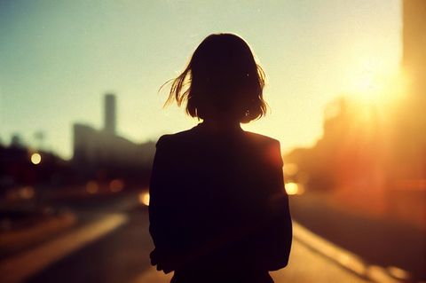 Silhouette einer Frau vor einer Stadt