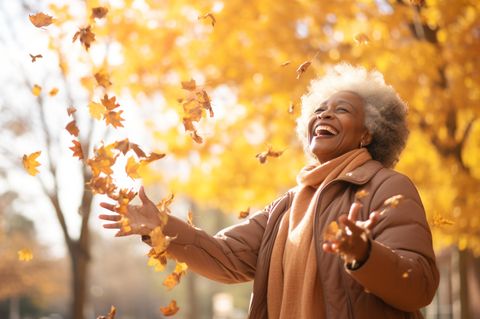 Wochenend-Horoskop ab 27.10.: Eine fröhliche Frau im Herbst