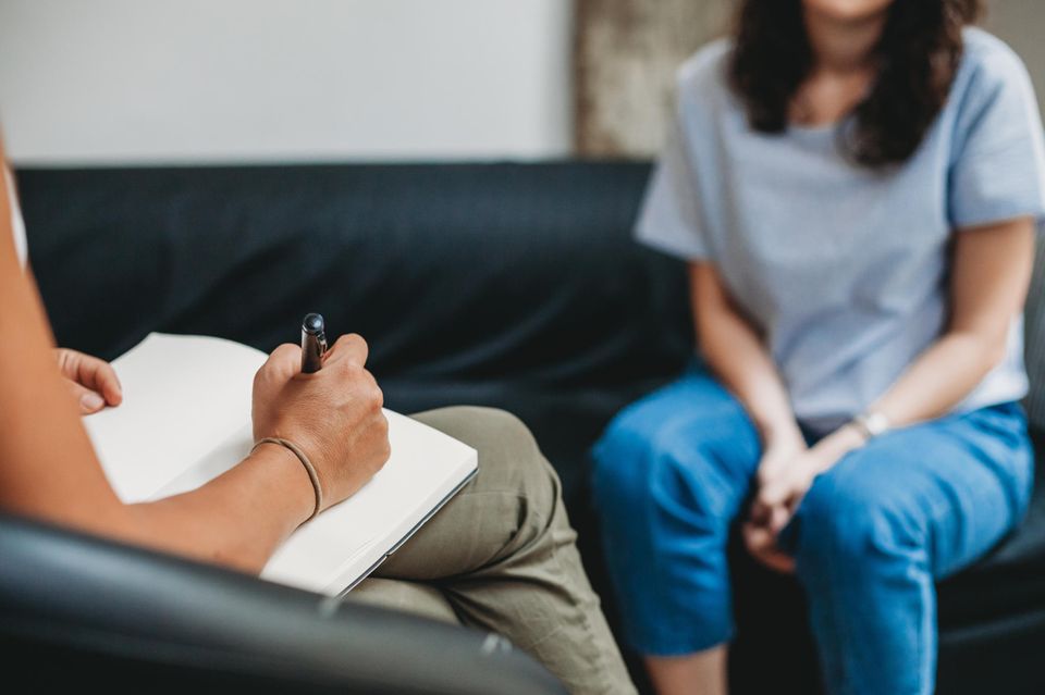 Therapieplatz finden: Frau sitzt auf Couch in Psychotherapie
