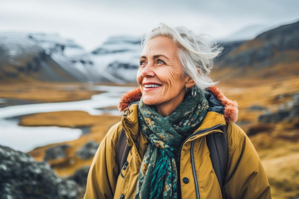 Lächelnde Frau wandert in den Bergen: Diese Gewohnheiten verraten mehr über deine Intelligenz, als du glaubst