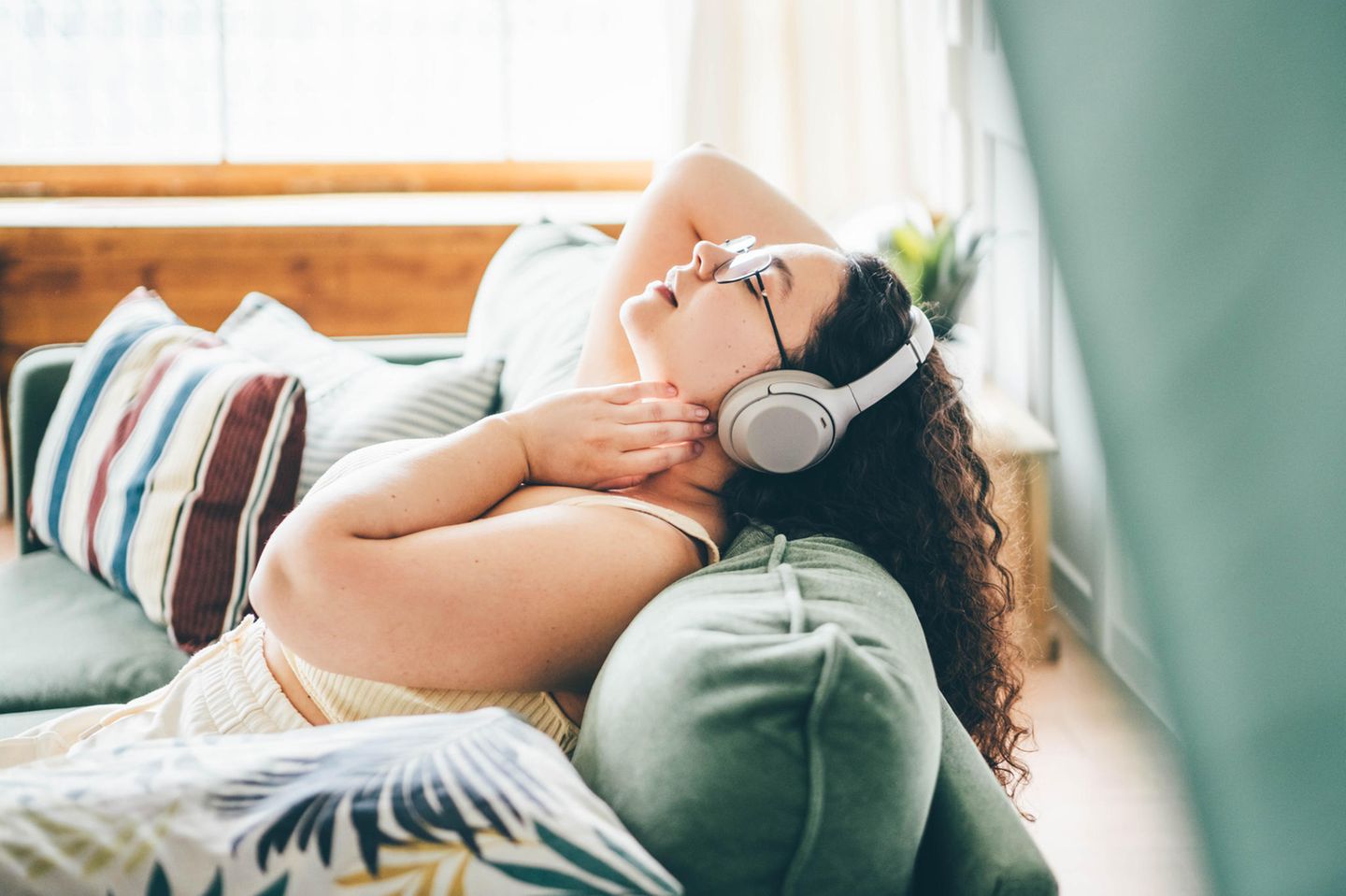 Frau mit Kopfhörern entspannt: 4 Gewohnheiten von Menschen, die (fast) immer ruhig bleiben