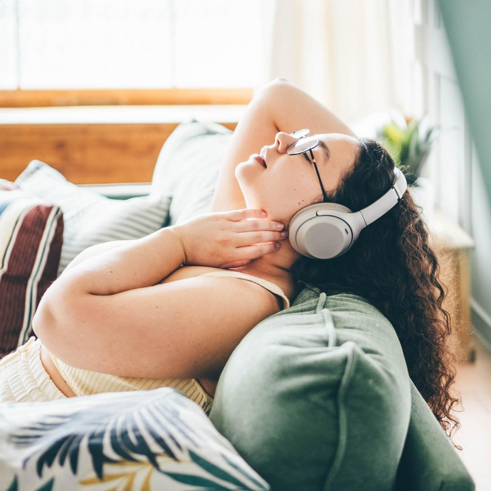 Frau mit Kopfhörern entspannt: 4 Gewohnheiten von Menschen, die (fast) immer ruhig bleiben