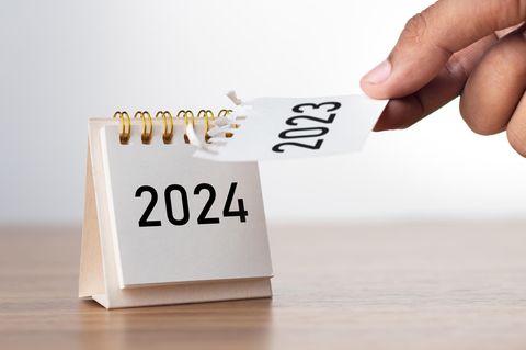 Eine Hand reißt das Blatt "2023" von einem Kalender ab