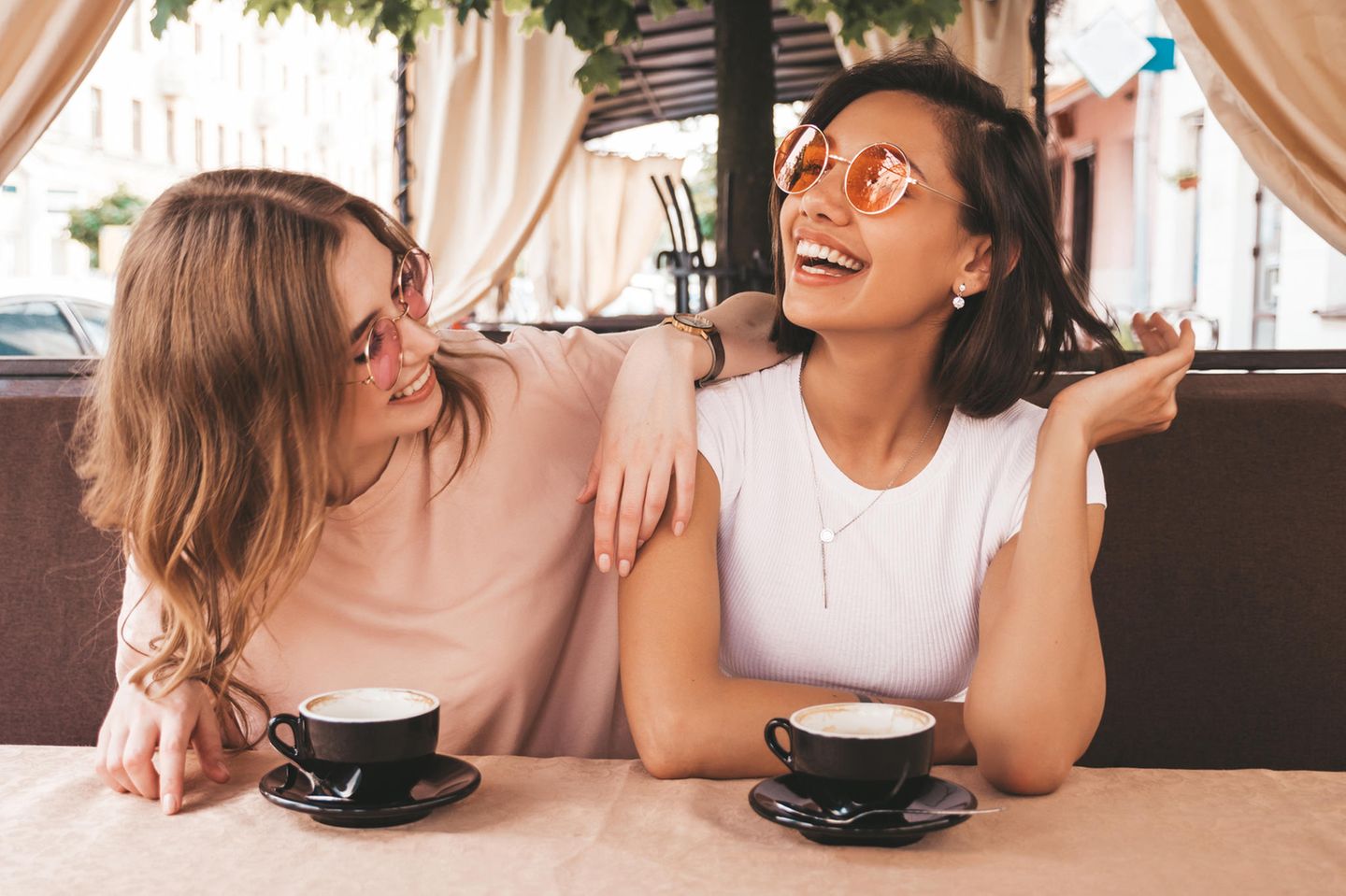 Zwei lachende Frauen im Gespräch: Was es über dich verrät, wie du mit Komplimenten umgehst