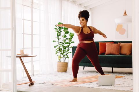 Frau macht Yoga zu Hause: Ist Cozy Cardio das perfekte Workout für den Winter?