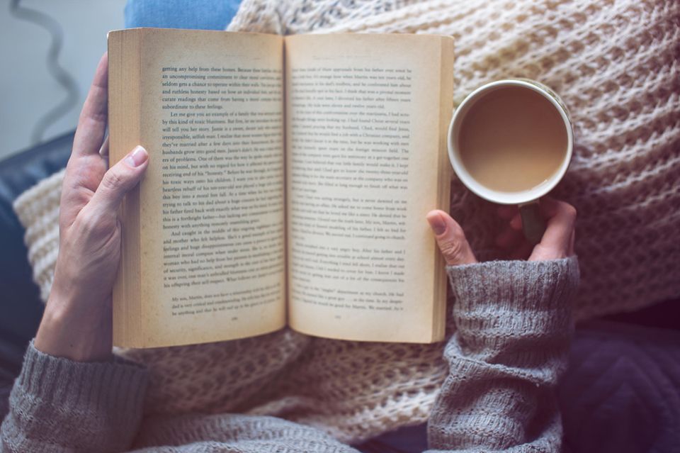 2023 war mein Jahr der 100 Bücher: Eine Frau mit Buch und Kaffee