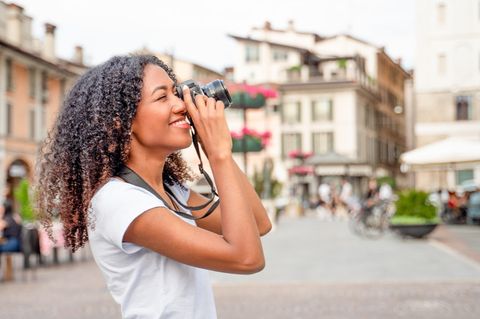Eine Frau fotografiert etwas in einer Stadt