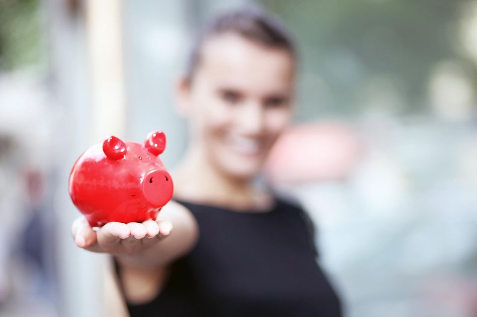 Finanzplanung: Frau hält Sparschwein in der Hand