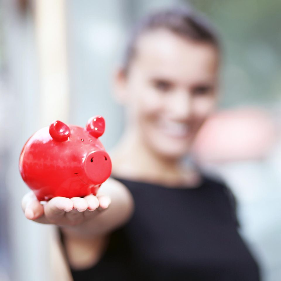 Finanzplanung: Frau hält Sparschwein in der Hand