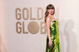 Ein verführerischer Blick für die Fotograf:innen: Taylor Swift weiß in smaragdgrünem Paillettenkleid zu bezaubern. Das bodenlange Stück mit seitlichen Brust-Cut-outs entstammt dem Hause Gucci. 
