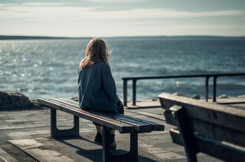 Nachdenkliche Frau schaut aufs Meer: 4 Anzeichen, dass du die Verbindung zu dir selbst verloren hast