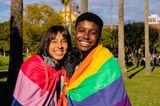 Zwei Menschen mit LGBTQIA+ Flaggen