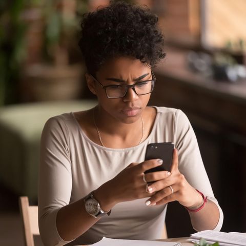 Frau schaut frustriert auf ihr Smartphone: 5 Strategien, wie du es endlich schaffst, dich weniger mit anderen zu vergleichen