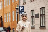 Die Designerin Pernile Rosenkilde besucht die Modenschauen in einem beigefarbenen Zweiteiler mit Fransen. Dazu kombiniert sie eine graue Mütze und eine Louis-Vuitton-Tasche