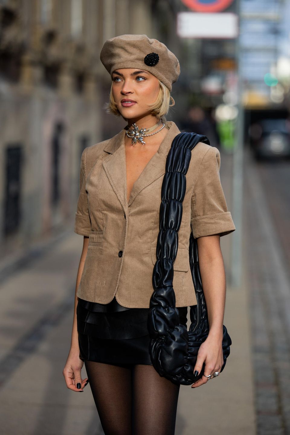 In diesem Look strahlt Emilia Silberg pure Eleganz aus! Die Influencerin trägt ein beigefarbenes Hemd aus Cord und kombiniert dazu ein perfekt abgestimmtes Barett. Abgerundet wird ihr Outfit mit einem schwarzen Minirock, einer schwarzen, gesteppten Tasche und einer extravaganten Kette.