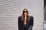 Dieser Gast der New York Fashion Week begeistert in einem oversized Anzug mit Nadelstreifen. Sie kombiniert dazu ein schwarzes Bralette, schwarze Lederhandschuhe, eine weiße Tasche und eine große Sonnenbrille.