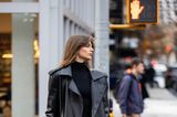 Die französische Influencerin Mara Lafontan wählt einen rockig-eleganten Look. Sie trägt einen ausgefransten, schwarzen Rock, ein Oberteil mit einem Rollkragen, einen schwarzen Trenchcoat aus Leder und einen extravaganten Gürtel. Auch sie besucht die Modenschau von Michael Kors.