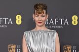 Nicht nur Stars aus Hollywood sind zu den BAFTAs eingeladen, Sandra Hüller, die nicht nur für den Oscar, sondern auch für den BAFTA nominiert ist, posiert im mattsilbernen Kleid von Louis Vuitton für die Fotograf:innen. 