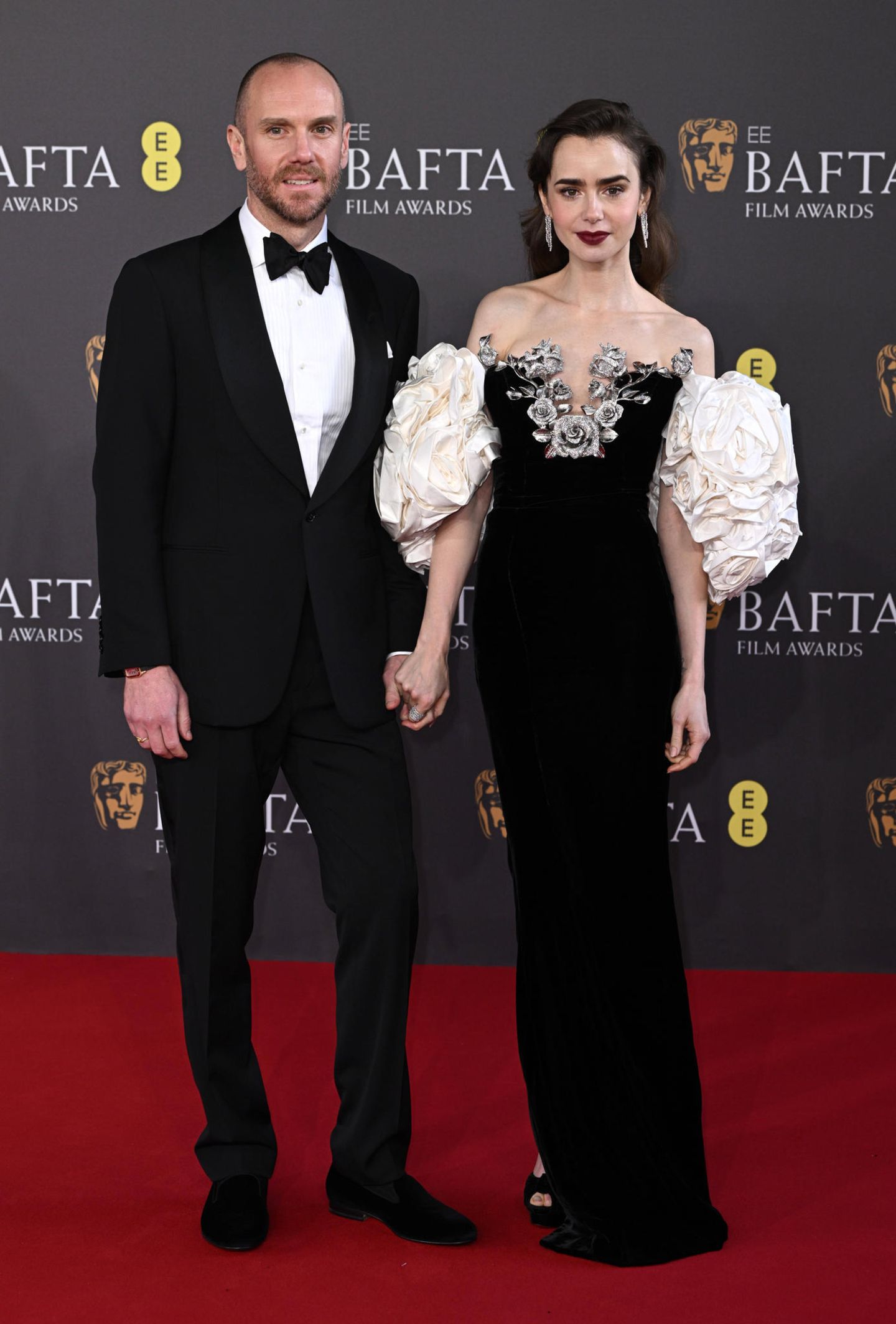Den wohl glamourösesten Auftritt bei den BAFTAs legt Lily Collins mit ihrem Ehemann Charlie McDowell hin. Wie einst für ihren Film "Spieglein Spieglein" schlüpft sie wieder in die Rolle des Schneewittchens. Porzellan-Haut, dunkle Haare und Lippen und ein prinzessinnenhaftes Kleid von Tamara Ralph. 