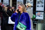 Eine Besucherin von Eudon Choi in London: Der Mix aus verschiedenen Materialien und Farben hebt die Spannung ihres Outfits um ein Vielfaches. Wer hätte gedacht, dass die Kombination aus grüner Tasche, blauem Mantel und pinkfarbener Brille einen Look so genial macht?