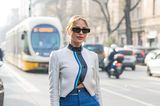 Denim-Looks sind und bleiben zeitlos. Das beweist auch dieser Gast der Mailänder Fashion Week. Zu einem langen Jeansrock kombiniert sie eine extravagante Bikerjacke, Sandaletten und eine coole Sonnenbrille.