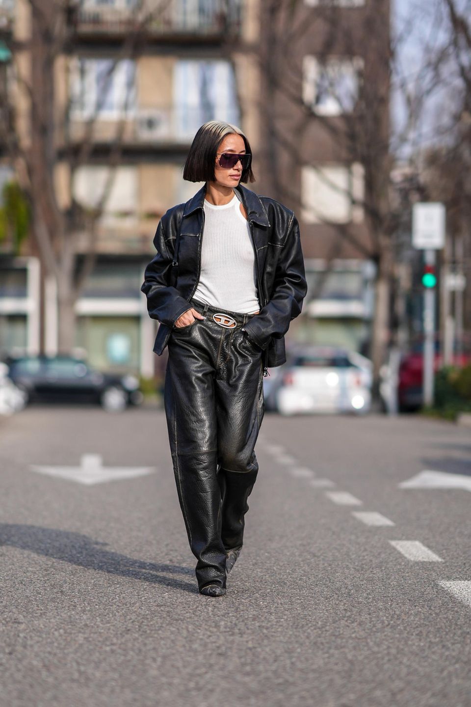 Cooler Gang, noch coolerer Look! Alexandra Guerain schlendert in einem Lederoutfit und einem weißen Tanktop durch Mailand. Selbst ihre Haare matchen den Look – gewollt oder nicht, es passt perfekt. 