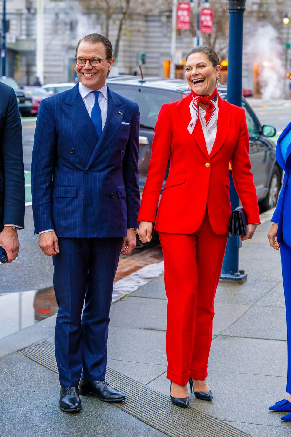 Fast genau wie ihr Lächeln strahlt auch der rote Anzug der Marke The Extreme Collection von Kronprinzessin Victoria. Abgerundet wird ihr Look durch ein farblich passendes Halstuch und durch die schwarzen, spitzen Pumps von Gianvito Rossi. 