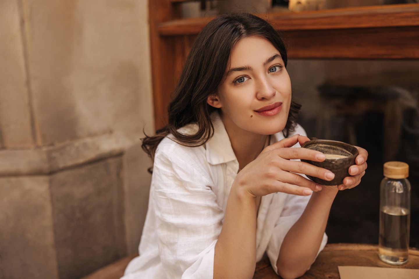 Glow Coffee: Junge Frau mit einer Tasse Kaffee