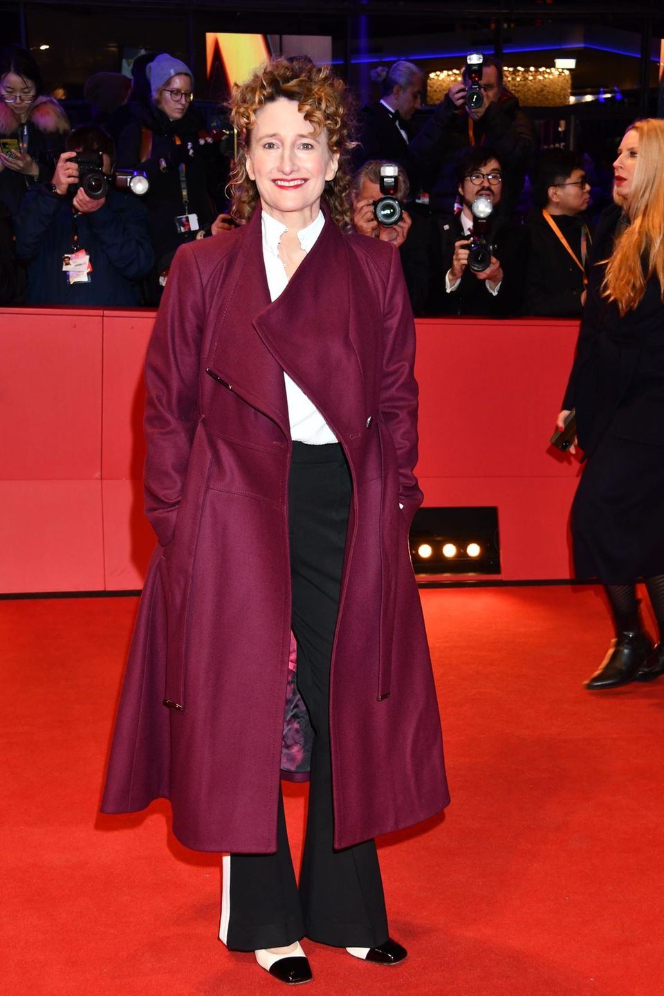 Da sich der Rote Teppich der Berlinale am Potsdamer Platz unter freiem Himmelt befindet, gebührt den Prominenten in hauchdünnen, kurzen Kleidern noch mehr Respekt. Filmfestivaldirektorin Tricia Tuttle kleidet sich den frostigen Temperaturen angemessen. Mit ihrem burgunderfarbenen Mantel liegt sie 2024 total im Trend. 