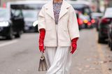 Creme und Rot ist ein Farbkombi, die dieser Fashionists mit Boucle-Jacke und langen Latexhandschuhen zu seidigem Faltenrock und Leoprint-Top ausgezeichnet steht. 