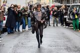 Influencerin Alexandra Pereira zieht mit ihrer dunkelbraunen XL-Jacke in Krokoleder-Optik und Missoni-Pullover zur knappen Pantyhose die Blicke aller Mailänder Fashion-Week-Fotograf:innen auf sich.