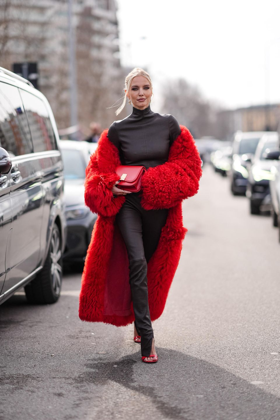In Mailand ist es derzeit auch noch nicht viel wärmer als in Deutschland, aber kalt wird Leonie Hanne in ihrem knallroten Kunstfellmantel zum schwarzem Rollkragen-Leder-Look mit roter Clutch und passenden 