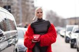 In Mailand ist es derzeit auch noch nicht viel wärmer als in Deutschland, aber kalt wird Leonie Hanne in ihrem knallroten Kunstfellmantel zum schwarzem Rollkragen-Leder-Look mit roter Clutch und passenden 