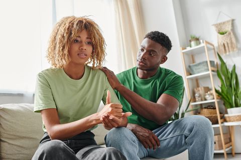 Paarkommunikation verbessern: Frau und Mann sitzen auf dem Sofa und reden