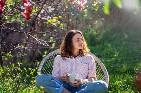 Frau genießt den Frühling im Garten: Wie diese 2-Minuten-Technik dir helfen kann, wenn alles zu viel wird