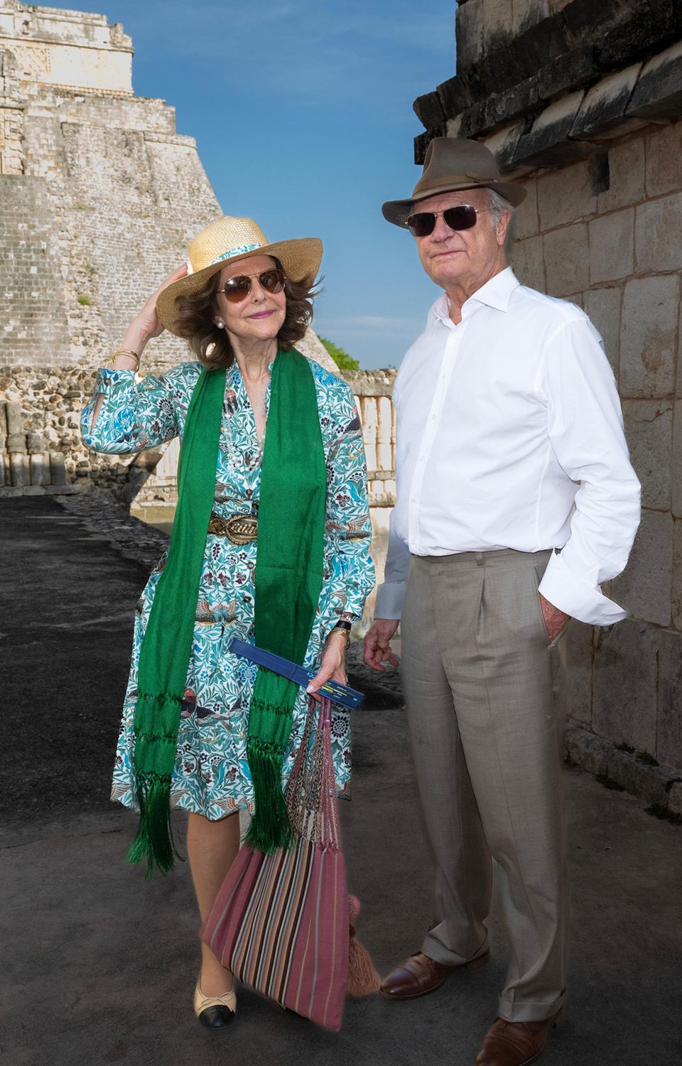 Bei diesem Bild kann man doch nur Lust auf Urlaub bekommen. Carl Gustaf und Silvia von Schweden strahlen in ihren Sommerlooks am dritten Tag ihres Staatsbesuchs in Mexiko. Ausgestattet mit Hüten, Fächern und Sonnenbrillen begeben sie sich auf eine Sightseeing-Tour durch Mexiko-Stadt. Silvia trägt dabei ein gemustertes Sommerkleid in Blau- und Brauntönen. Dazu kombiniert sie ein grünes Tuch, trendige Ballerinas und einen goldschimmernden Gürtel. Ihre Accessoires sind ebenfalls Gold. Carl Gustaf setzt bei dem Ausflug auf ein legeres, weißes Hemd und eine graue Hose.