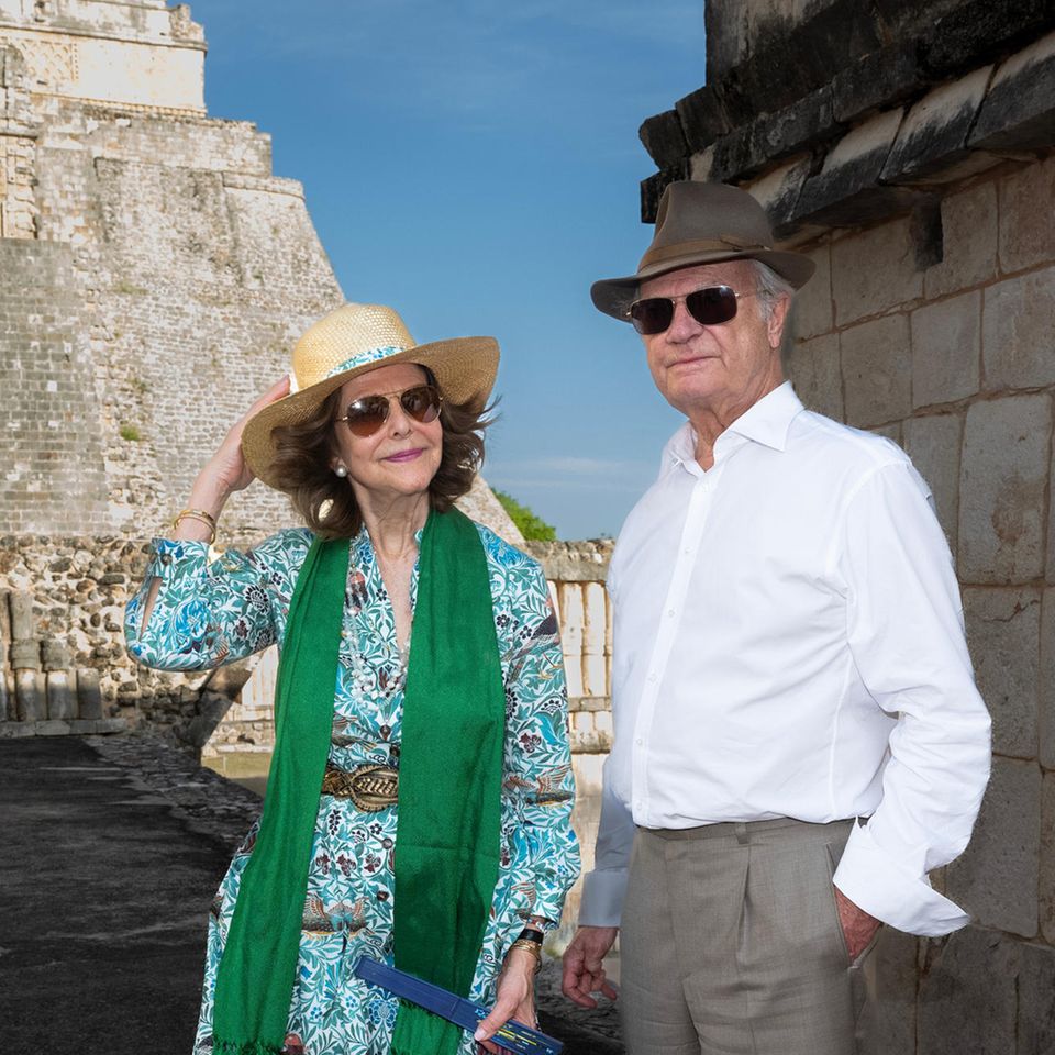 Bei diesem Bild kann man doch nur Lust auf Urlaub bekommen. Carl Gustaf und Silvia von Schweden strahlen in ihren Sommerlooks am dritten Tag ihres Staatsbesuchs in Mexiko. Ausgestattet mit Hüten, Fächern und Sonnenbrillen begeben sie sich auf eine Sightseeing-Tour durch Mexiko-Stadt. Silvia trägt dabei ein gemustertes Sommerkleid in Blau- und Brauntönen. Dazu kombiniert sie ein grünes Tuch, trendige Ballerinas und einen goldschimmernden Gürtel. Ihre Accessoires sind ebenfalls Gold. Carl Gustaf setzt bei dem Ausflug auf ein legeres, weißes Hemd und eine graue Hose.