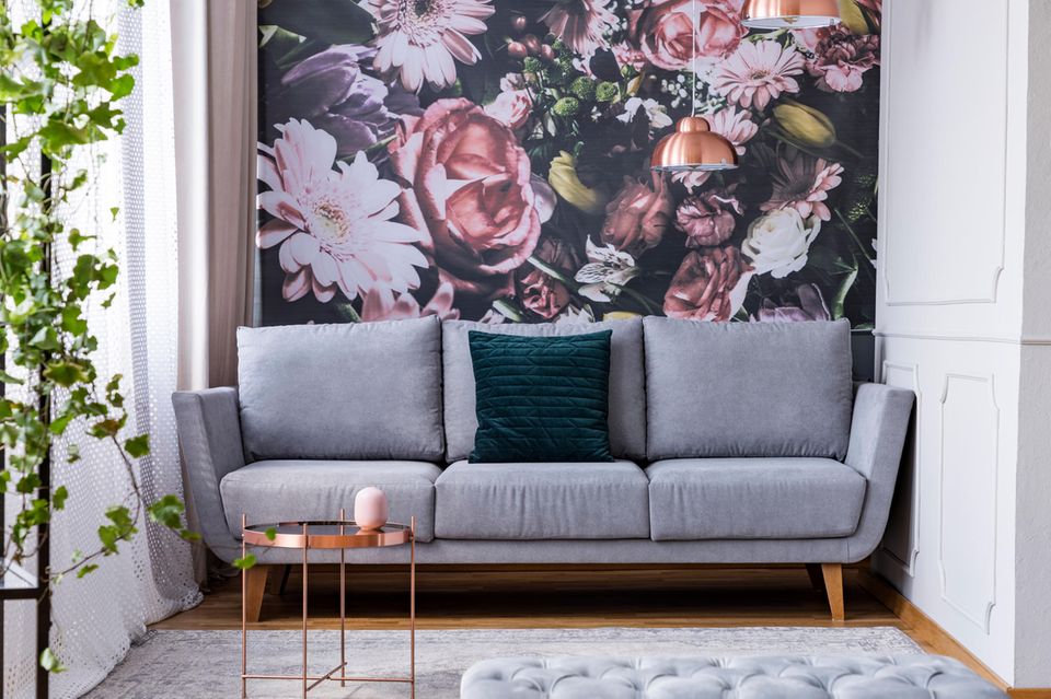 Wandgestaltung Wohnzimmer: Sofa vor einer Blumen-Motivwand