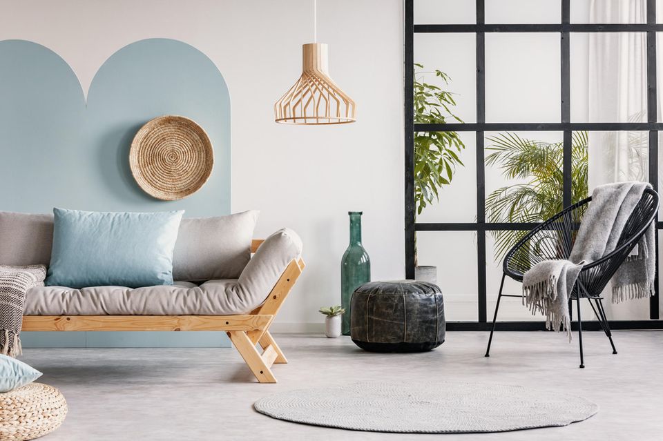 Wandgestaltung Wohnzimmer: Raum mit Sofa, Sessel sowie blauem Muster an der Wand