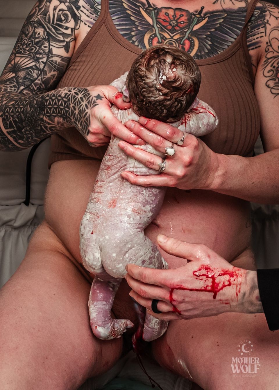 Geburtsfotografie 2024: Mutter hält ihr neugeborenes Baby