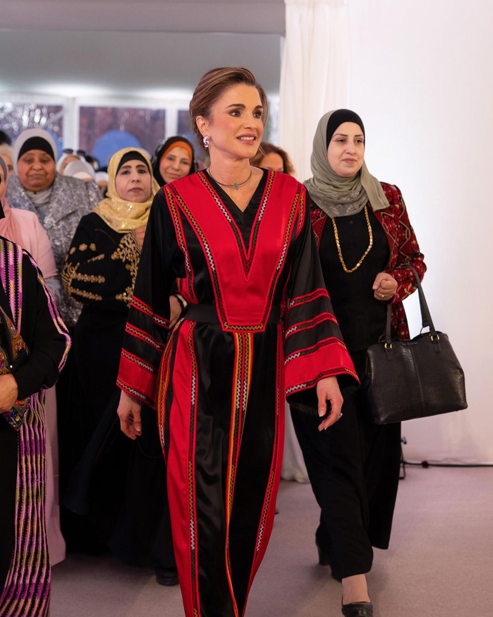 Elegant in Schwarz-Rot besucht Königin Rania ein Iftar-Mahl in Amman. Dabei schafft es dir jordanische Königin einmal mehr, Tradition und Modernität zu vereinen. Sie trägt ein traditionelles Kleid mit leicht ausgestellten Ärmeln und ergänzt den Look mit stilvollen silbernen Kreolen, die ihm einen modernen und trendigen Touch verleihen. 