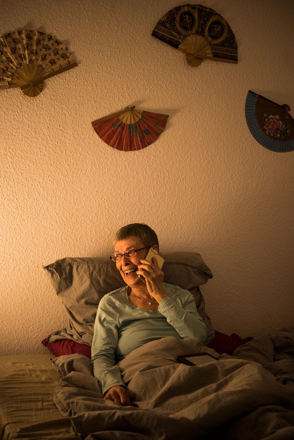 Hallo und Auf Wiedersehen: Frau sitzt im Bett und telefoniert