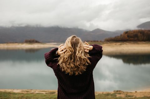 Frau schaut auf einen See: 3 Momente im Leben, in denen es sogar gut sein kann, sich verloren zu fühlen
