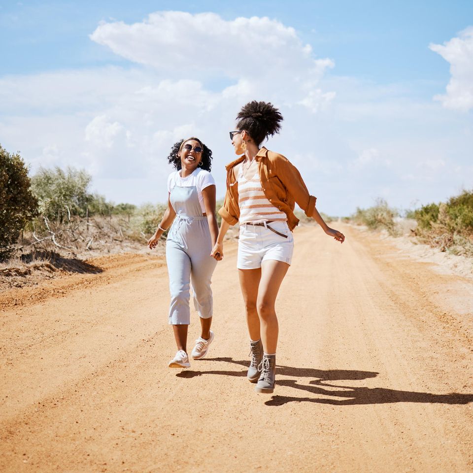 Zwei Frauen sind fröhlich in der Natur: 4 subtile Signale, dass du deinen persönlichen Lebenssinn gefunden hast