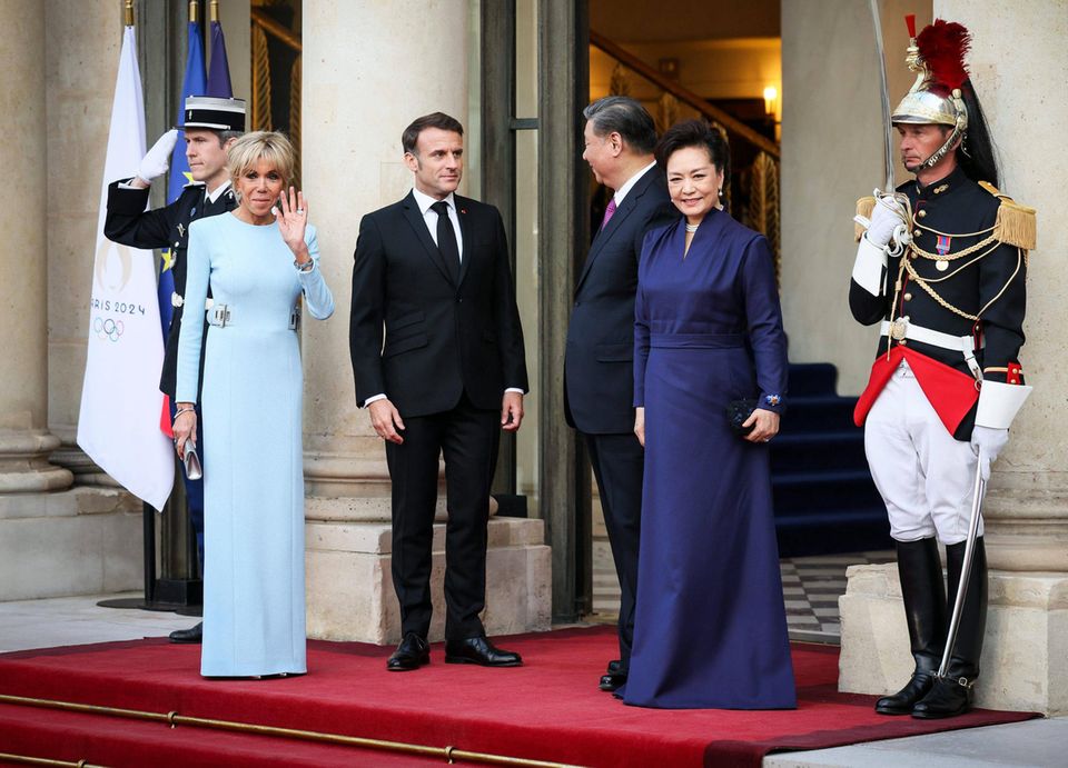 Für das abendliche Staatsbankett im Elysée-Palast hat sich nicht nur Frankreichs Première Dame einen eleganten und gleichermaßen modernen Look in Hellblau ausgesucht, auch Peng Liyuan, die Ehefrau des chinesischen Präsidenten Xi Jinping, sieht im navyblauen Abendkleid hinreißend aus.