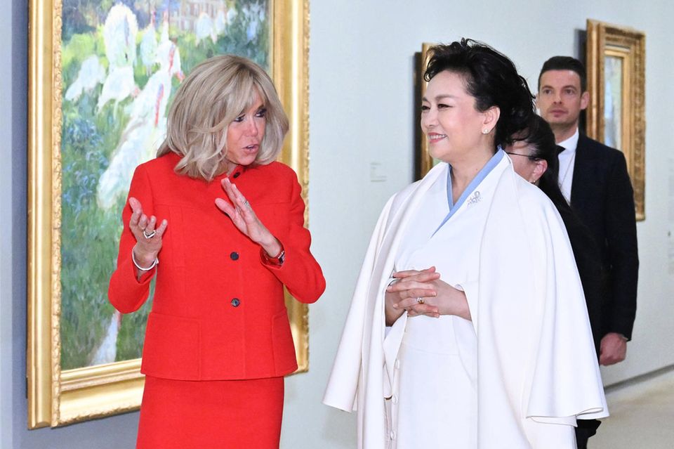 Nach dem ersten Empfang des Staatsbesuchs aus China geht es für die beiden First Ladys gleich auf einen kulturellen Ausflug ins Musée D'Orsay. Während Brigitte Macron in einem roten Dior-Ensemble leuchtet, zeigt sich Peng Liyuan in einem traditionellem Outfit in Weiß mit eleganten Mantel darüber