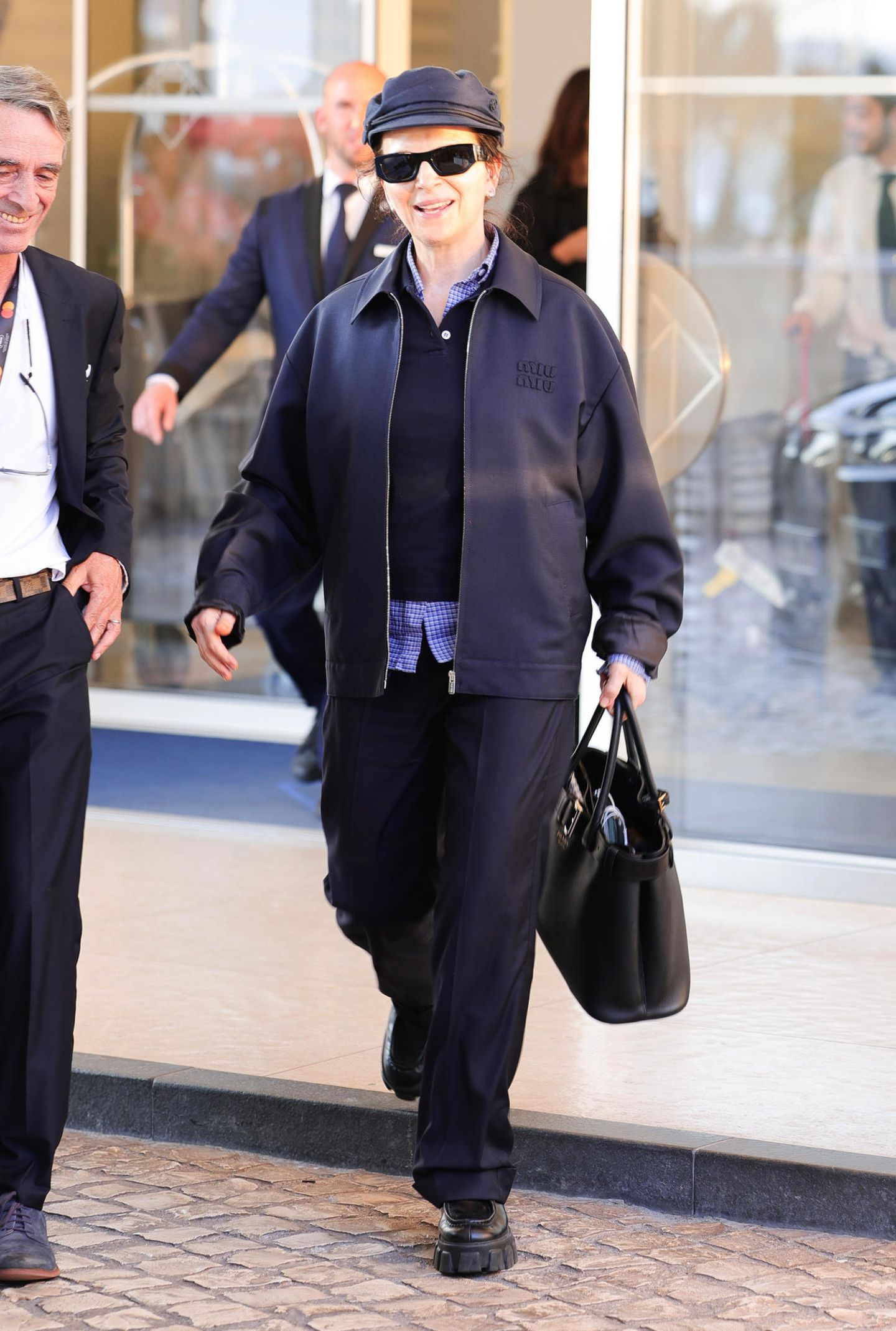 Kaum zu erkennen ist Juliette Binoche im coolen, dunkelblauen Outfit mit Miu-Miu-Jacke und mit lässiger Schiebermütze.